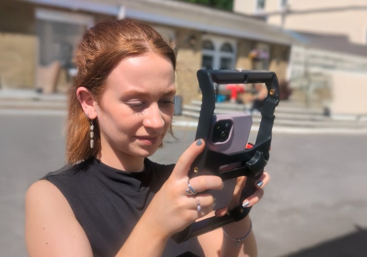 A woman filming on her smartphone